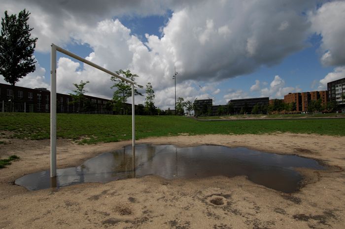 Waslijnen wapperen op IJburg, met kinderfotokunst