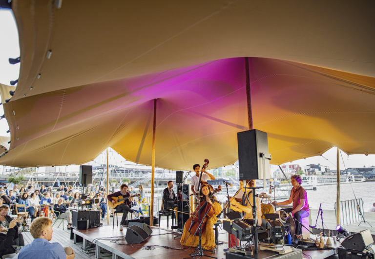 Zonsondergang bij het Muziekgebouw: een zomer lang terrasconcerten aan het IJ